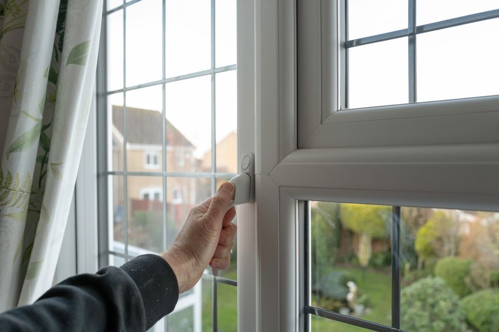 A person is opening a window in a house.