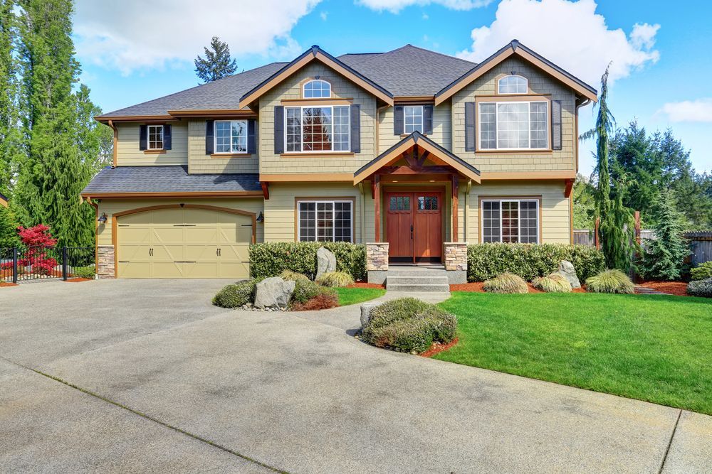A large house with a large driveway in front of it.