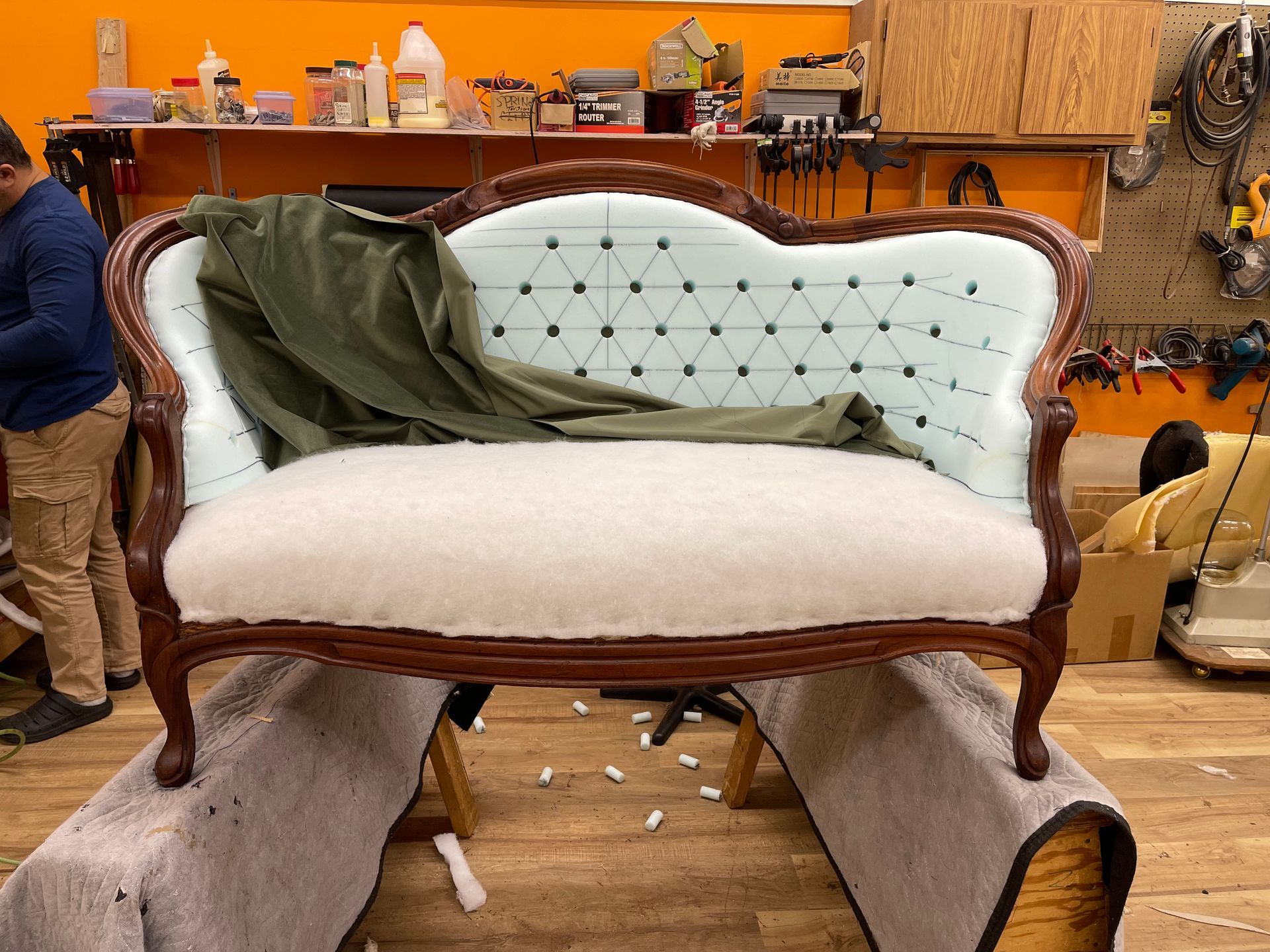 A man is working on a couch in a workshop