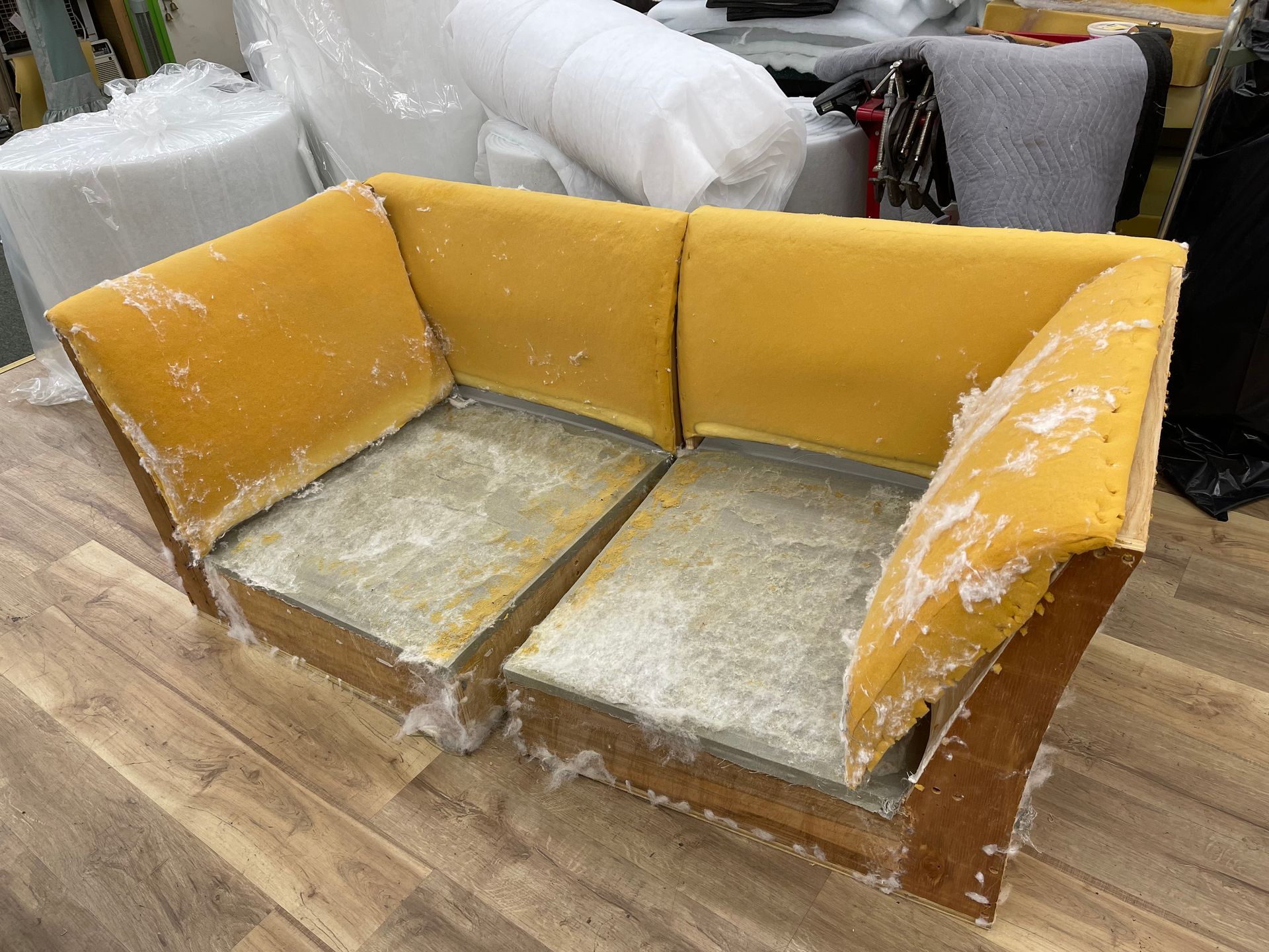 A yellow couch is sitting on top of a wooden table.