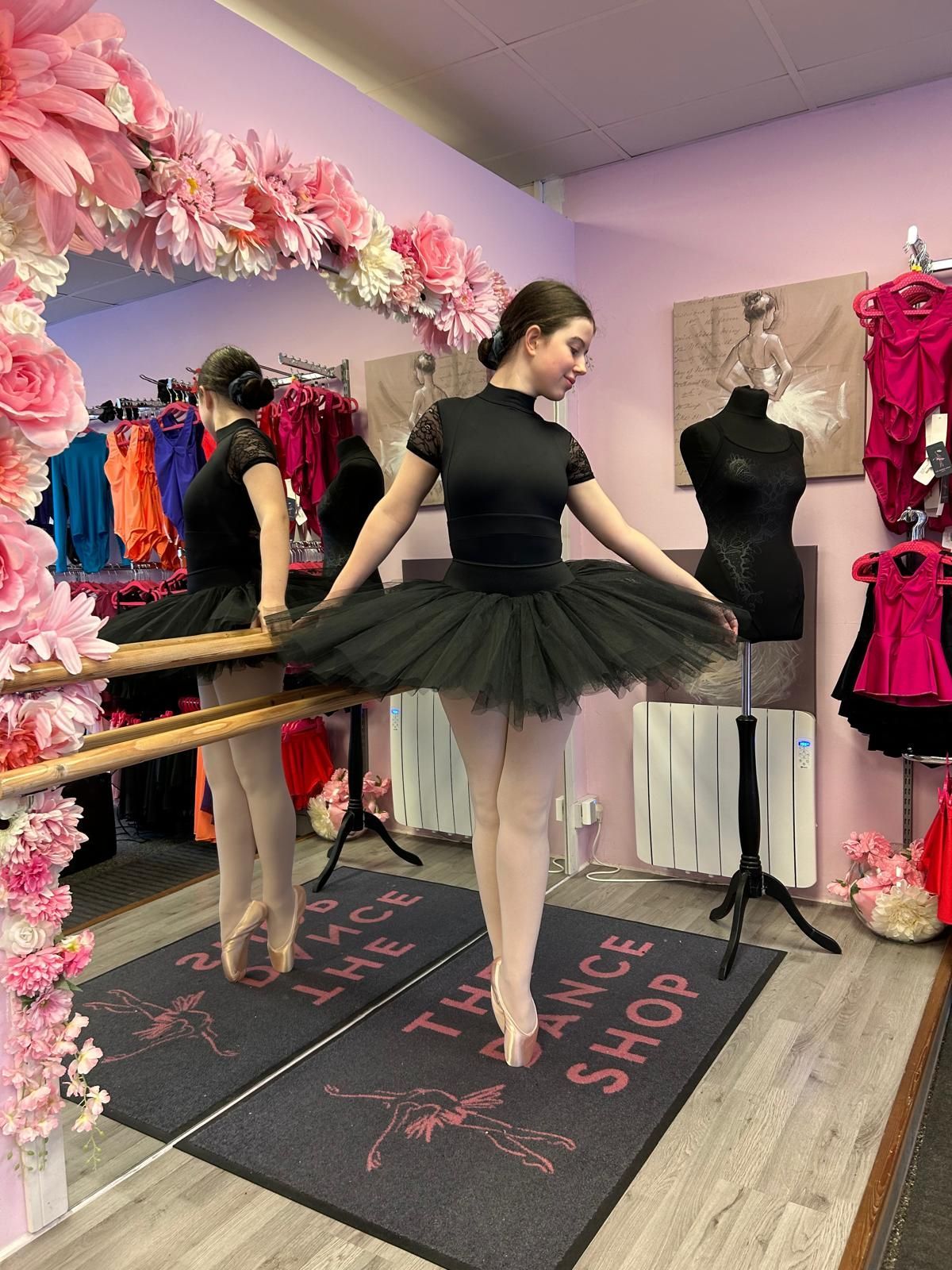 Dancer practising pointe at a ballet barre in a black tutu