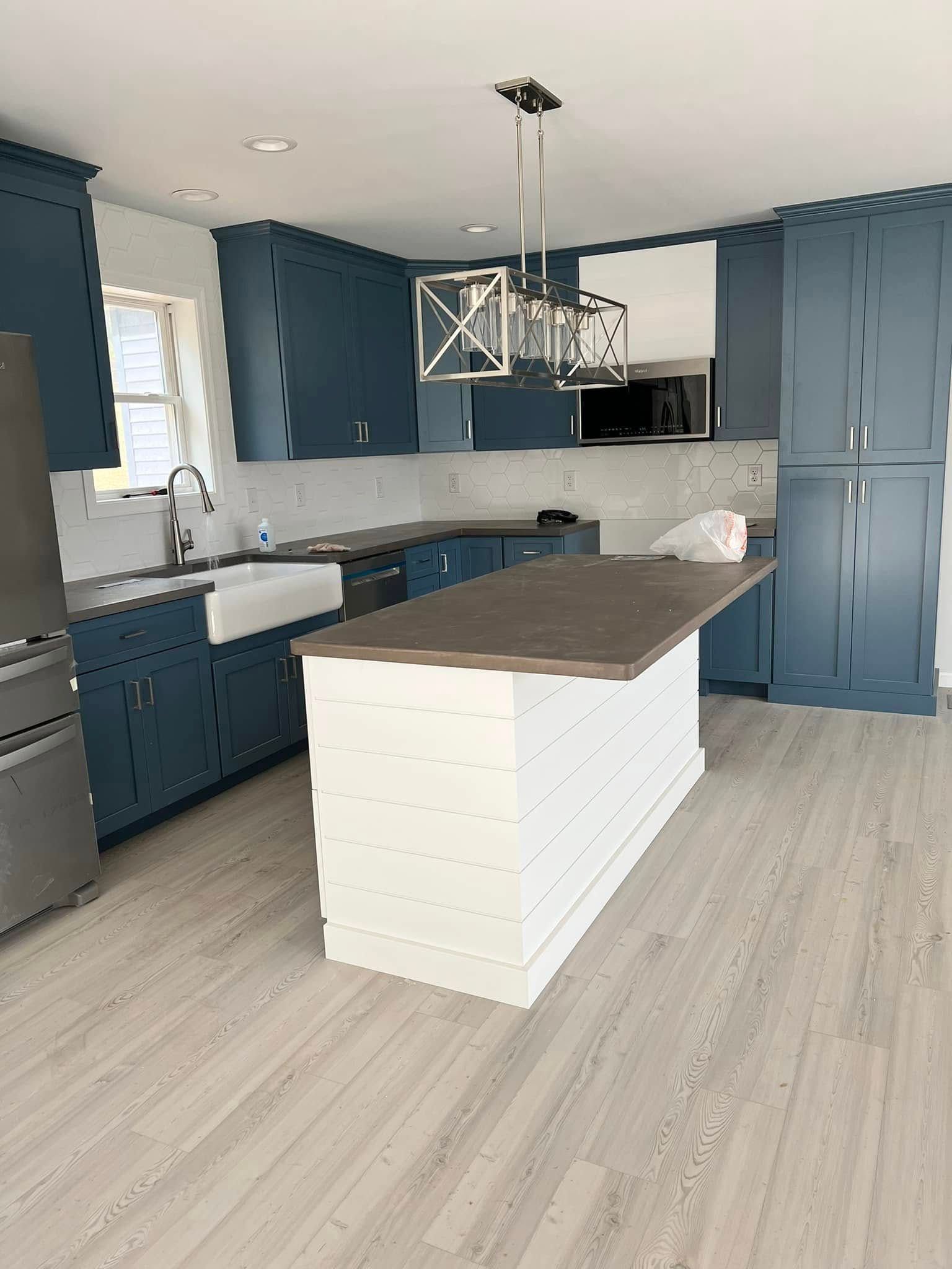 Modern kitchen with blue cabinets, wood island, and light flooring