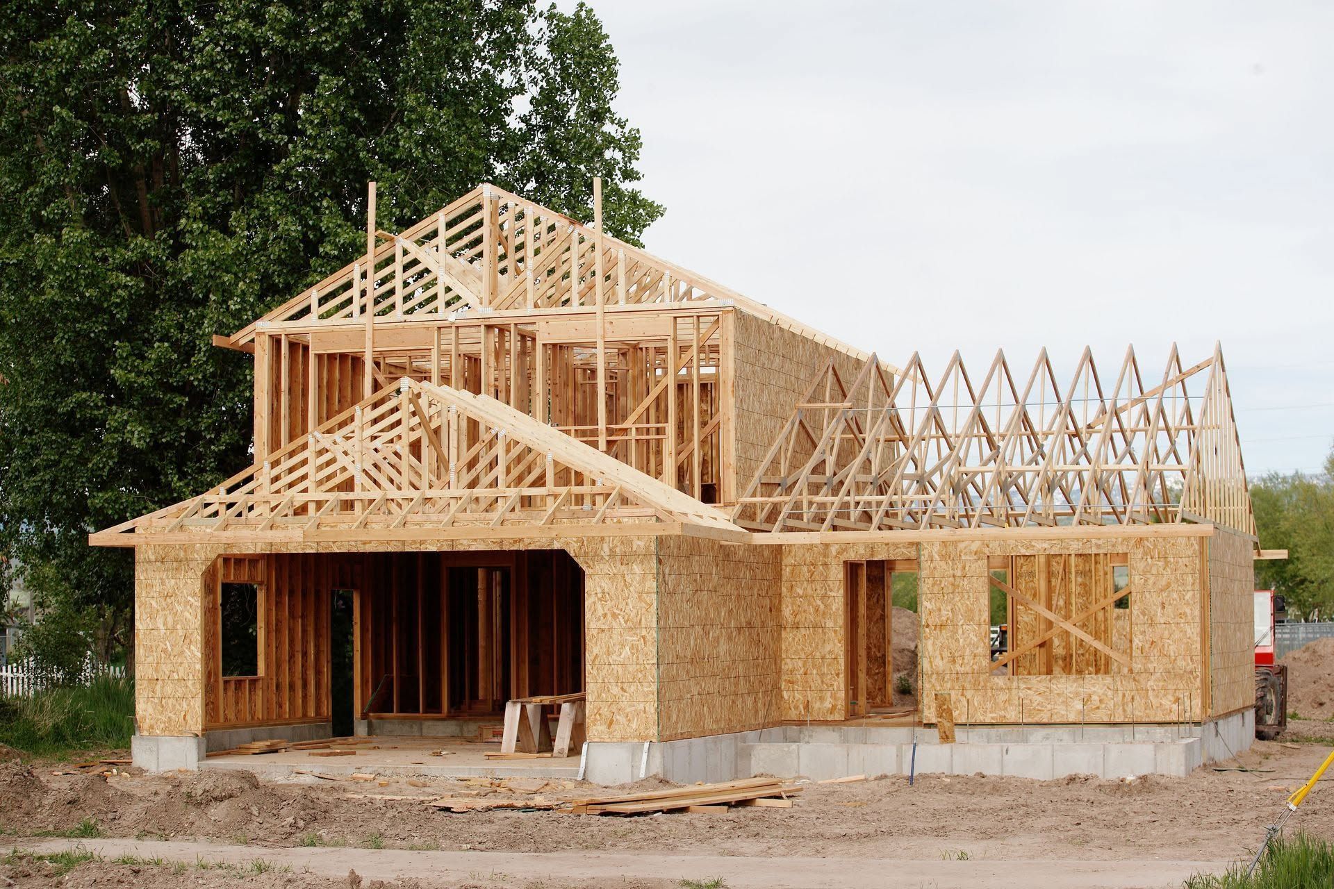 Partially built house with wooden frame and sheathing at a construction site