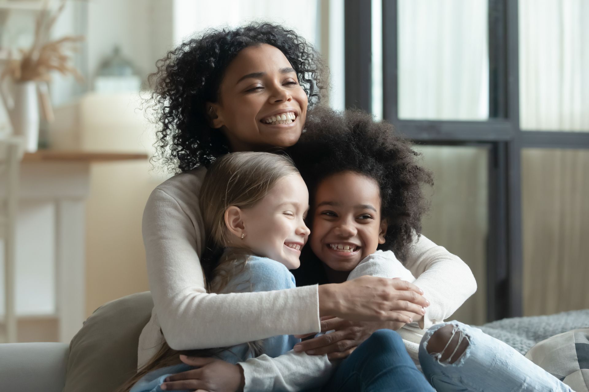 woman is hugging two girls.