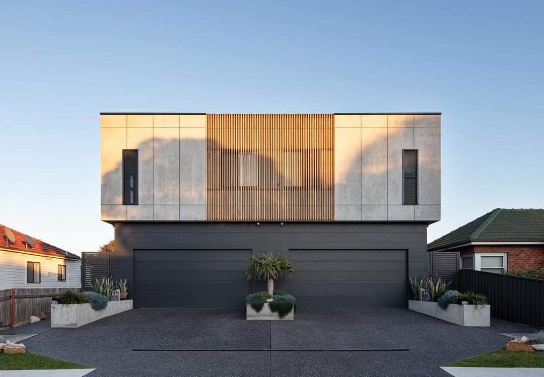 A Modern House with Two Garages and A Driveway in Front of It — Bootle Timber QLD Pty Ltd in Garbutt, QLD