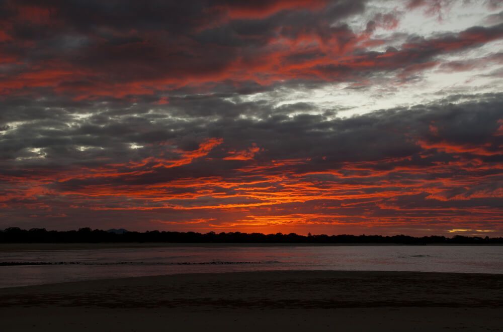 A Sunset Over a Body of Water With a Cloudy Sky — Bootle Timber QLD Pty Ltd in Mackay, QLD