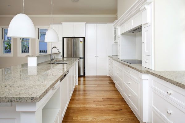 Modern White Kitchen with Steel Fridge — Bootle Timber QLD Pty Ltd in Garbutt, QLD