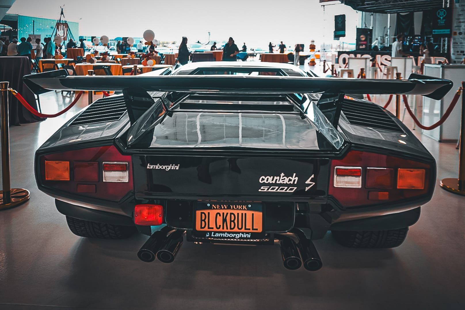 Rear view of a black Lamborghini Countach 5000S with a large spoiler and a custom 