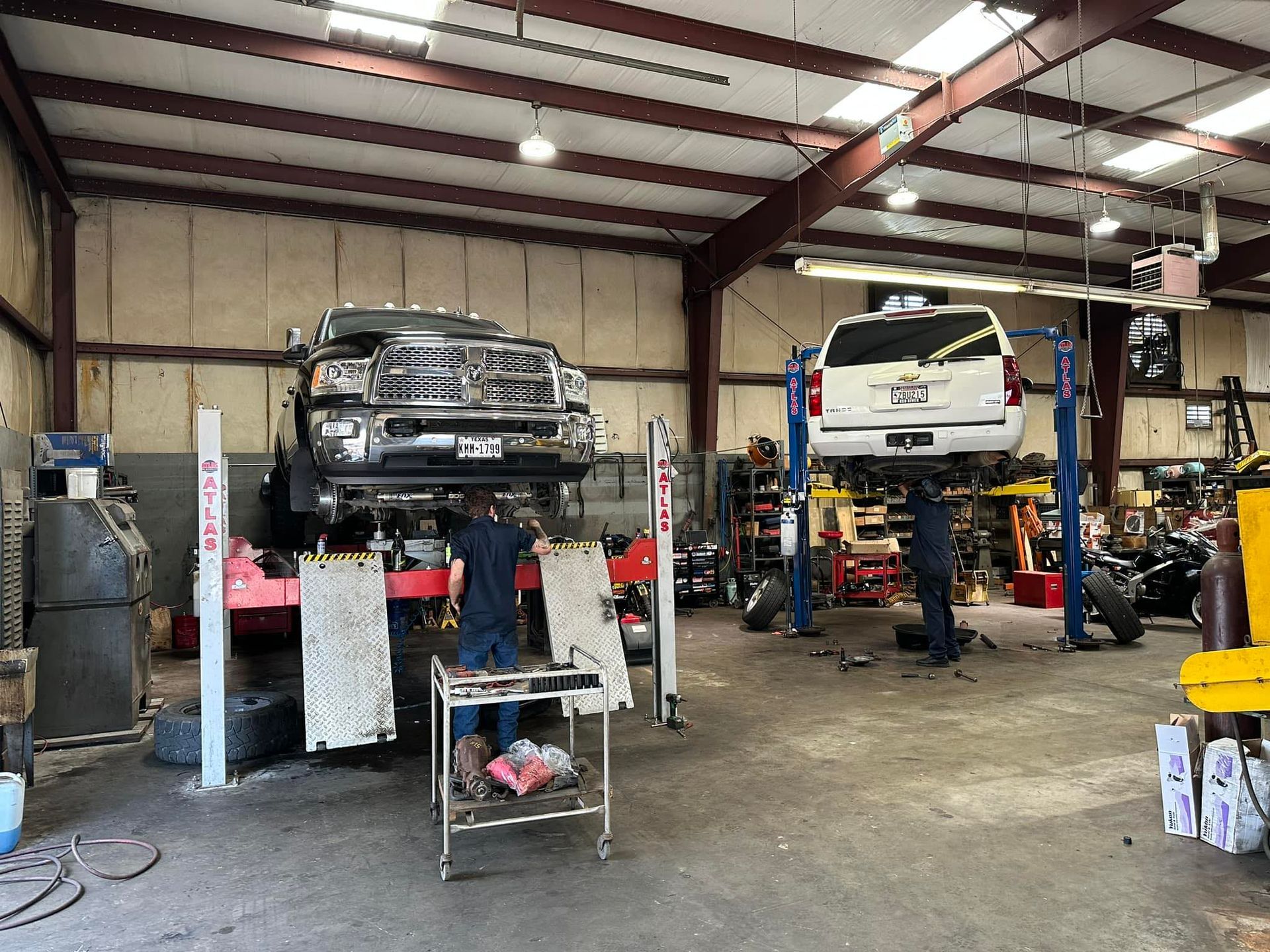 A truck and a van are being worked on in a garage.
