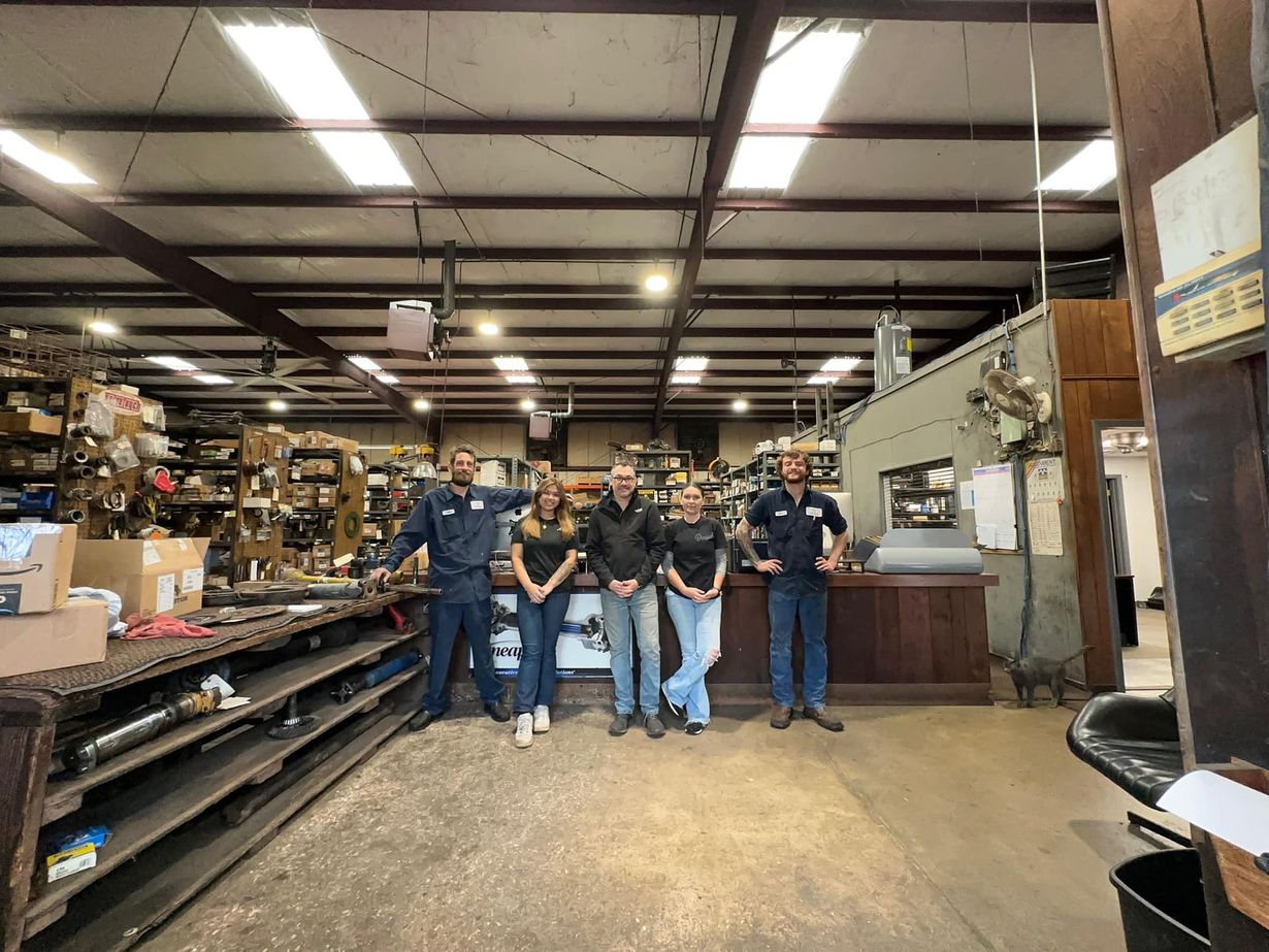 A group of people are posing for a picture in a factory.