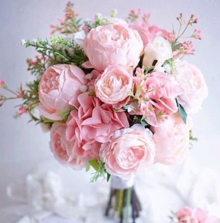 Pink and white floral bouquet with peonies and greenery.