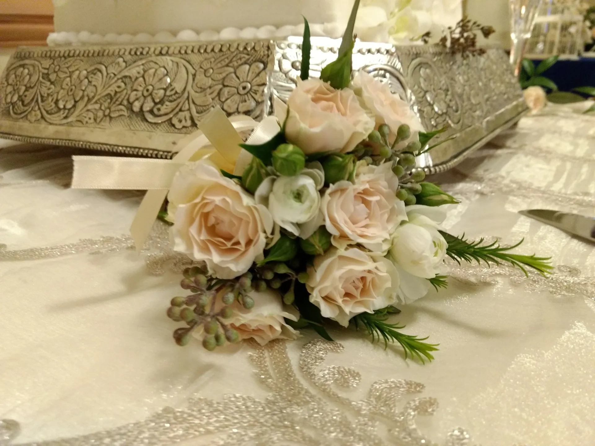 Bouquet of cream and pink roses on a decorated white table.