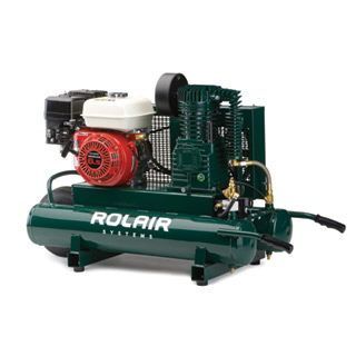 A red air compressor is sitting on a blue towel on the ground.