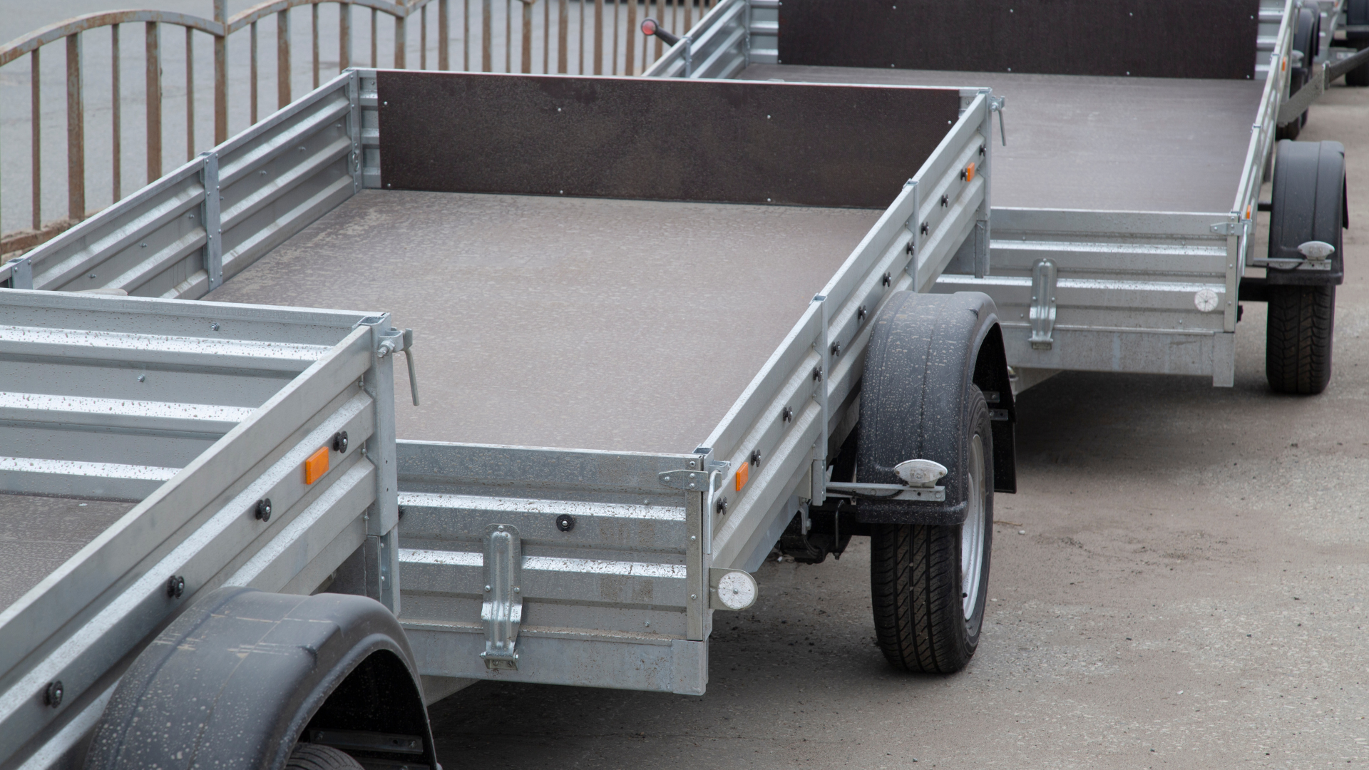 A trailer with a wooden floor is parked in the grass