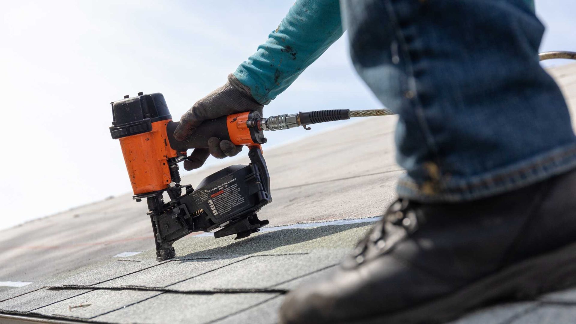 a nail gun being used on a roof