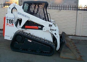 A bobcat t190 is parked in front of a fence.
