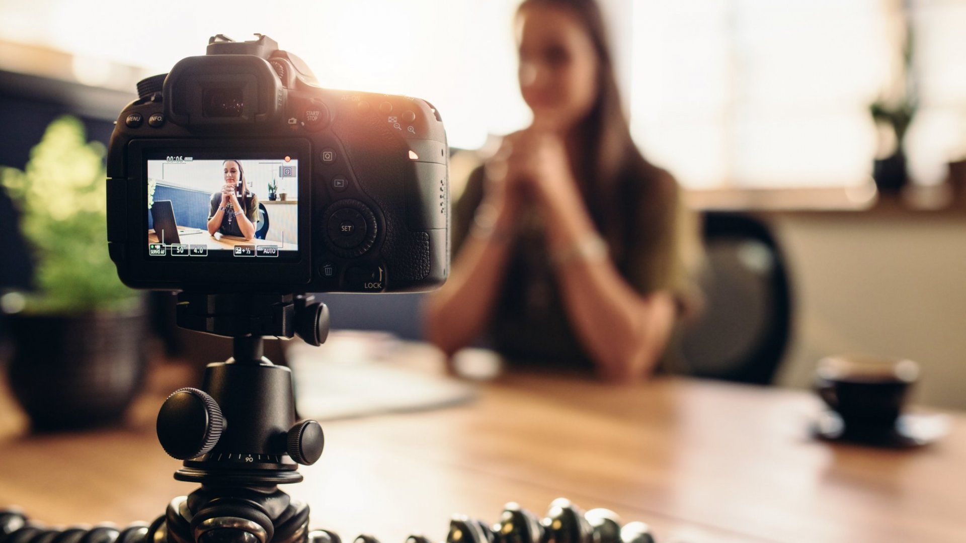 Woman sitting in front of a video camera recording a video CV and cover letter
