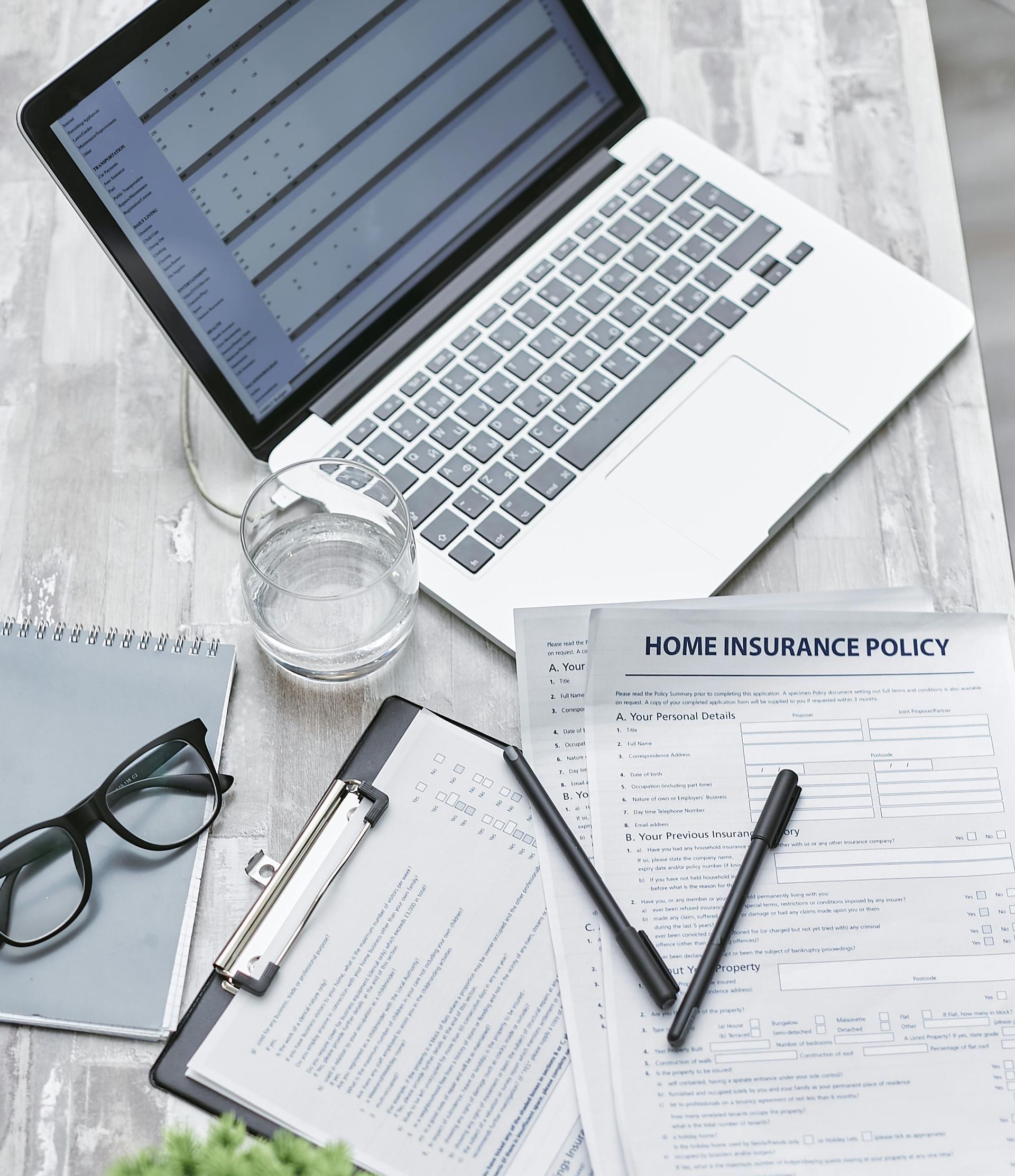San Diego estate planning attorney reviewing a home insurance policy with a client to prevent denied claims for a property held in trust.