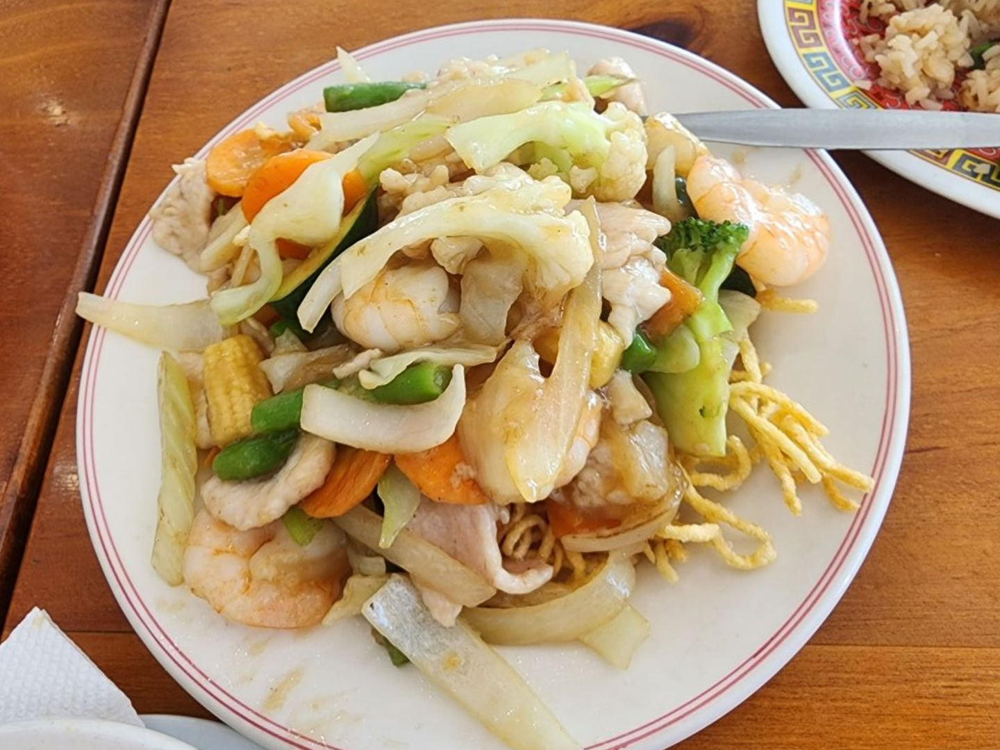 A White Plate Topped With Noodles and Vegetables on a Wooden Table — Kowin Restaurant in Harrington, NSW