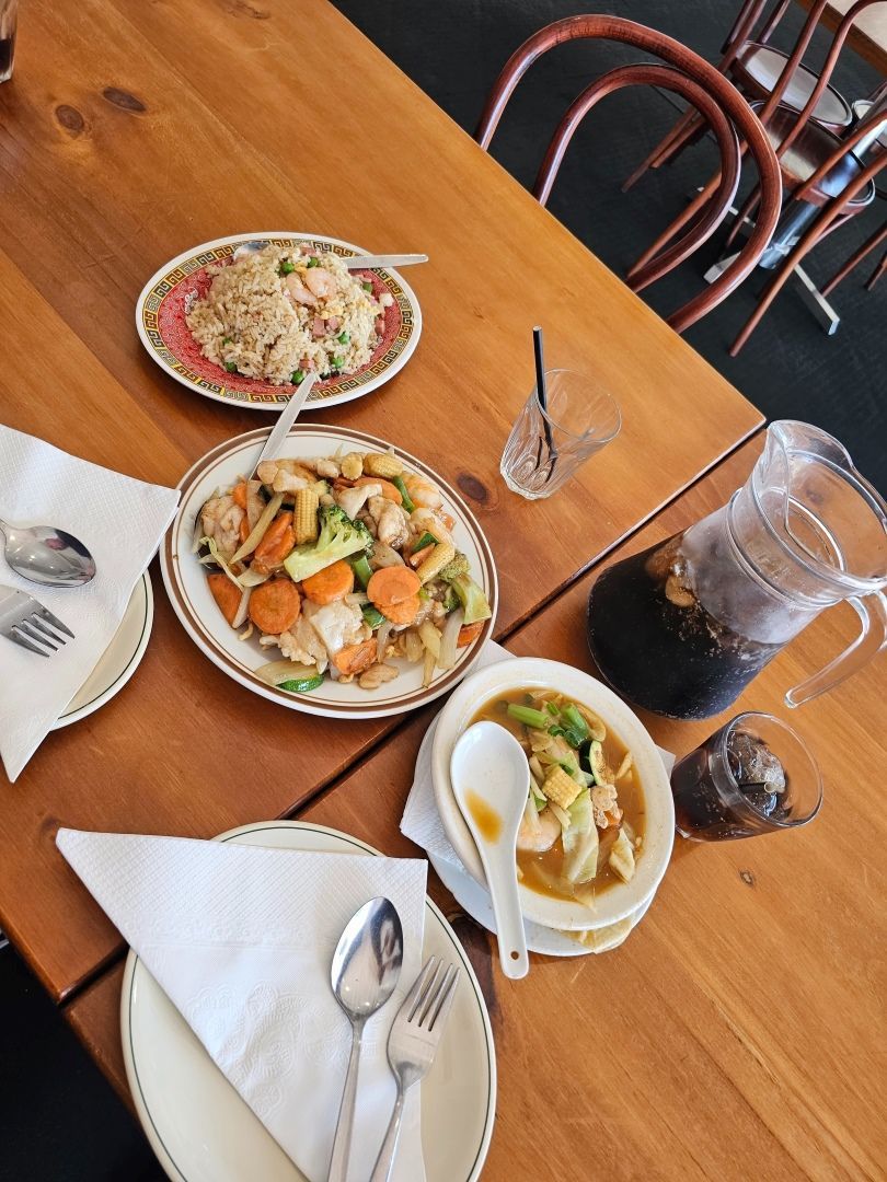 A Wooden Table Topped With Plates of Food and Utensils — Kowin Restaurant in Taree, NSW
