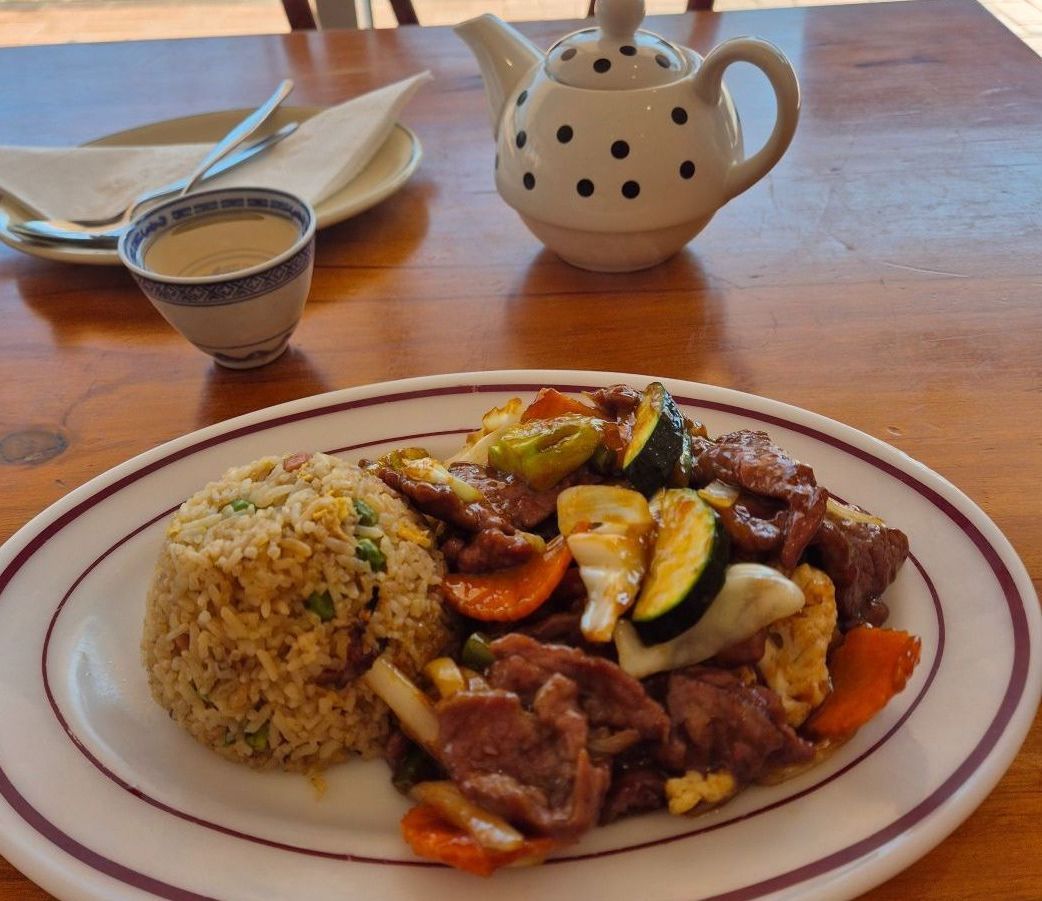 A Plate of Food on a Table Next to a Teapot — Kowin Restaurant in Taree, NSW