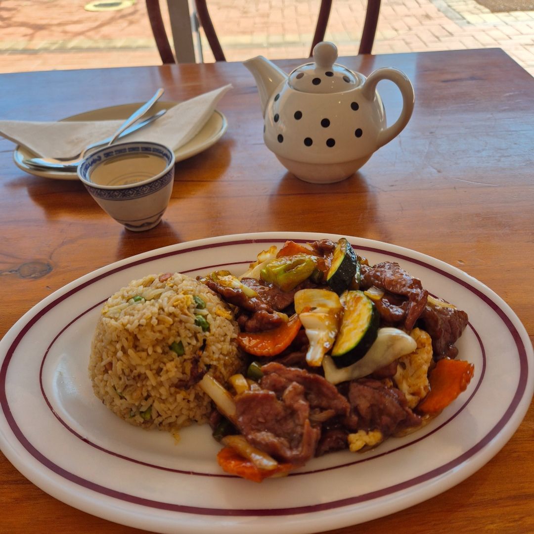 A Plate of Food on a Table Next to a Teapot — Kowin Restaurant in Wingham, NSW