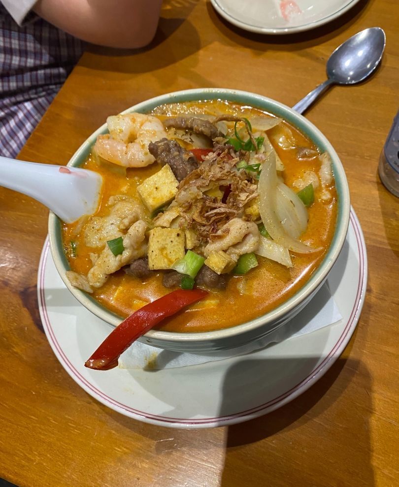 A Bowl of Soup With a Spoon in It on a Wooden Table — Kowin Restaurant in Taree, NSW