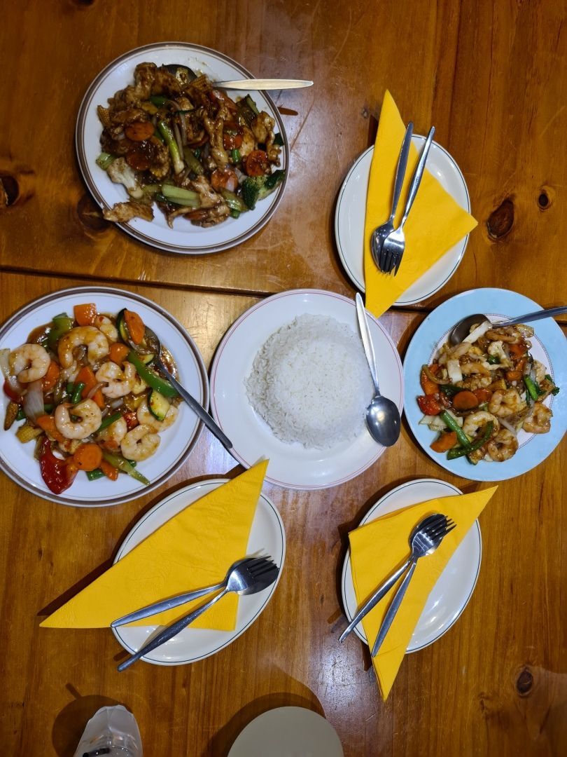 A Wooden Table Topped With Plates of Food and Utensils — Kowin Restaurant in Taree, NSW