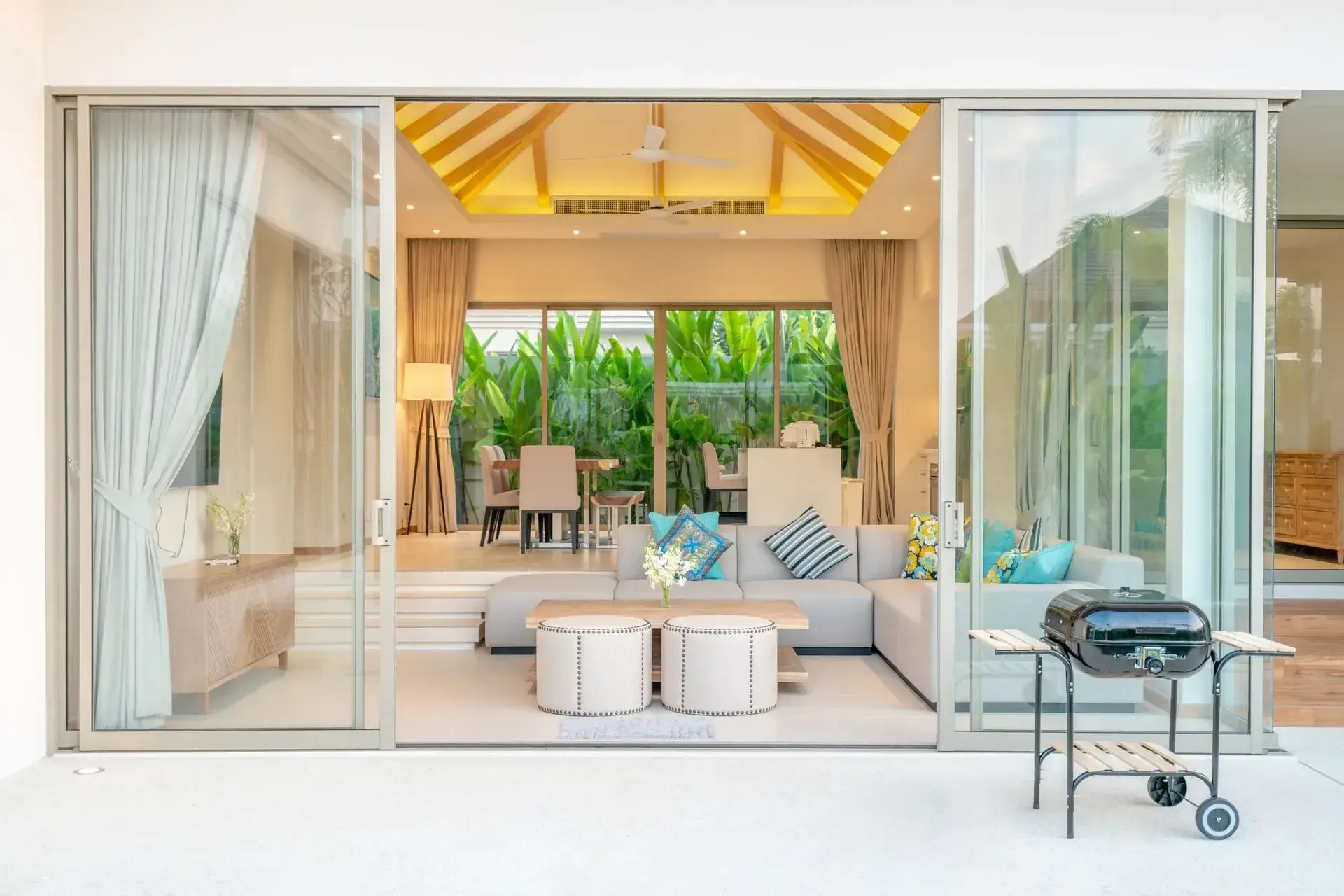 Sliding glass doors open to a living room with a grill on the patio.