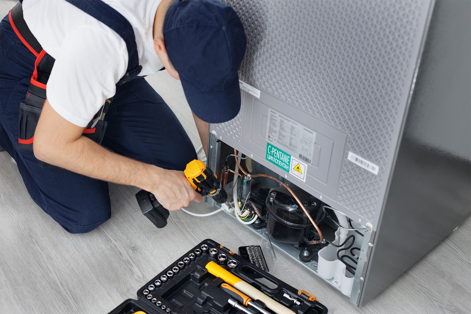 Technician Repairing a Refrigerator