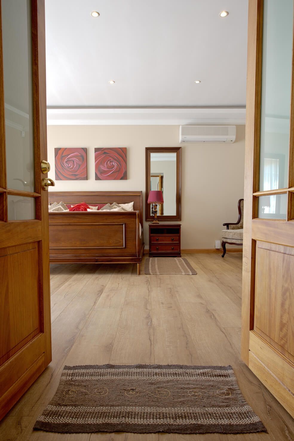 A doorway leading to a bedroom with a rug on the floor.