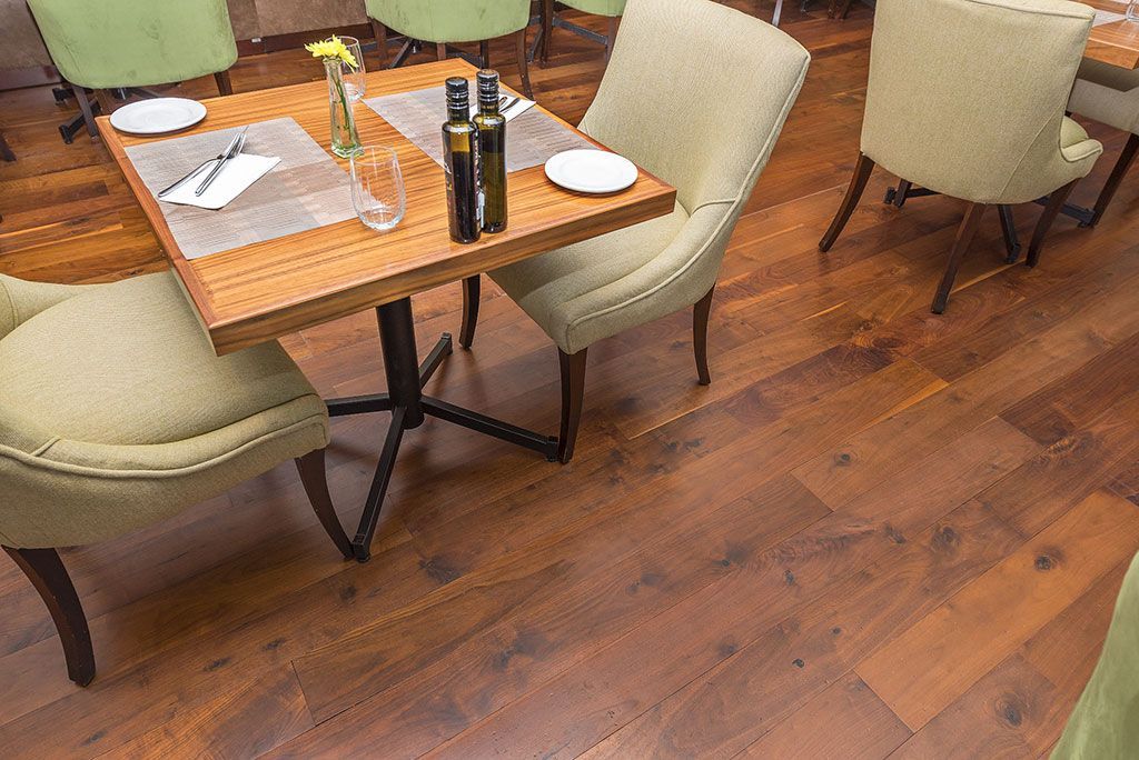 A restaurant with wooden floors and tables and chairs.