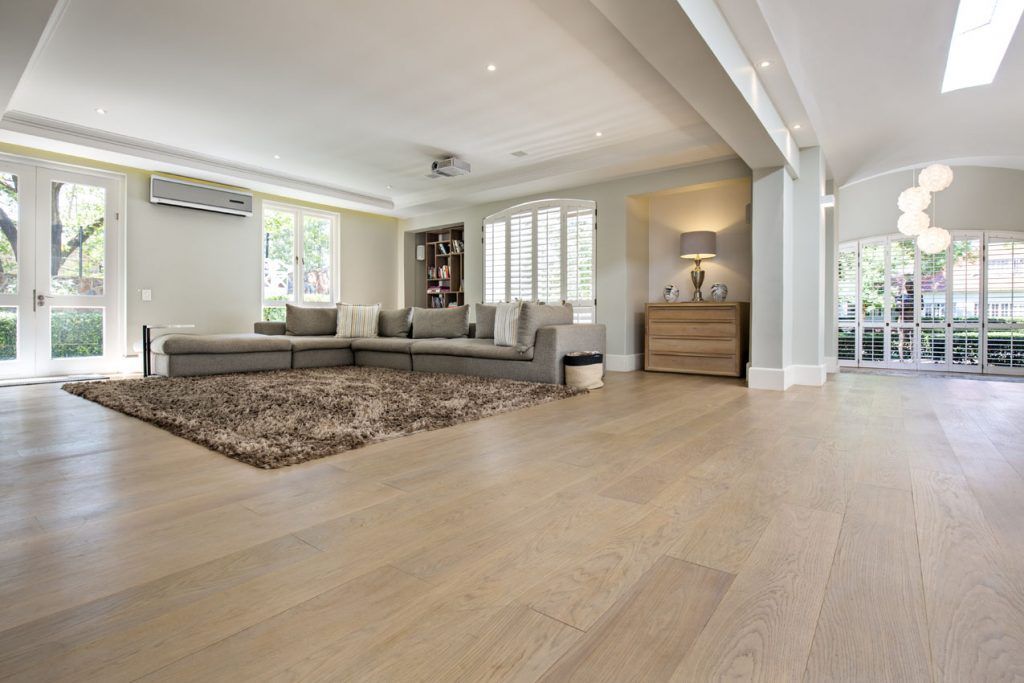 A living room with hardwood floors , a couch , and a rug.