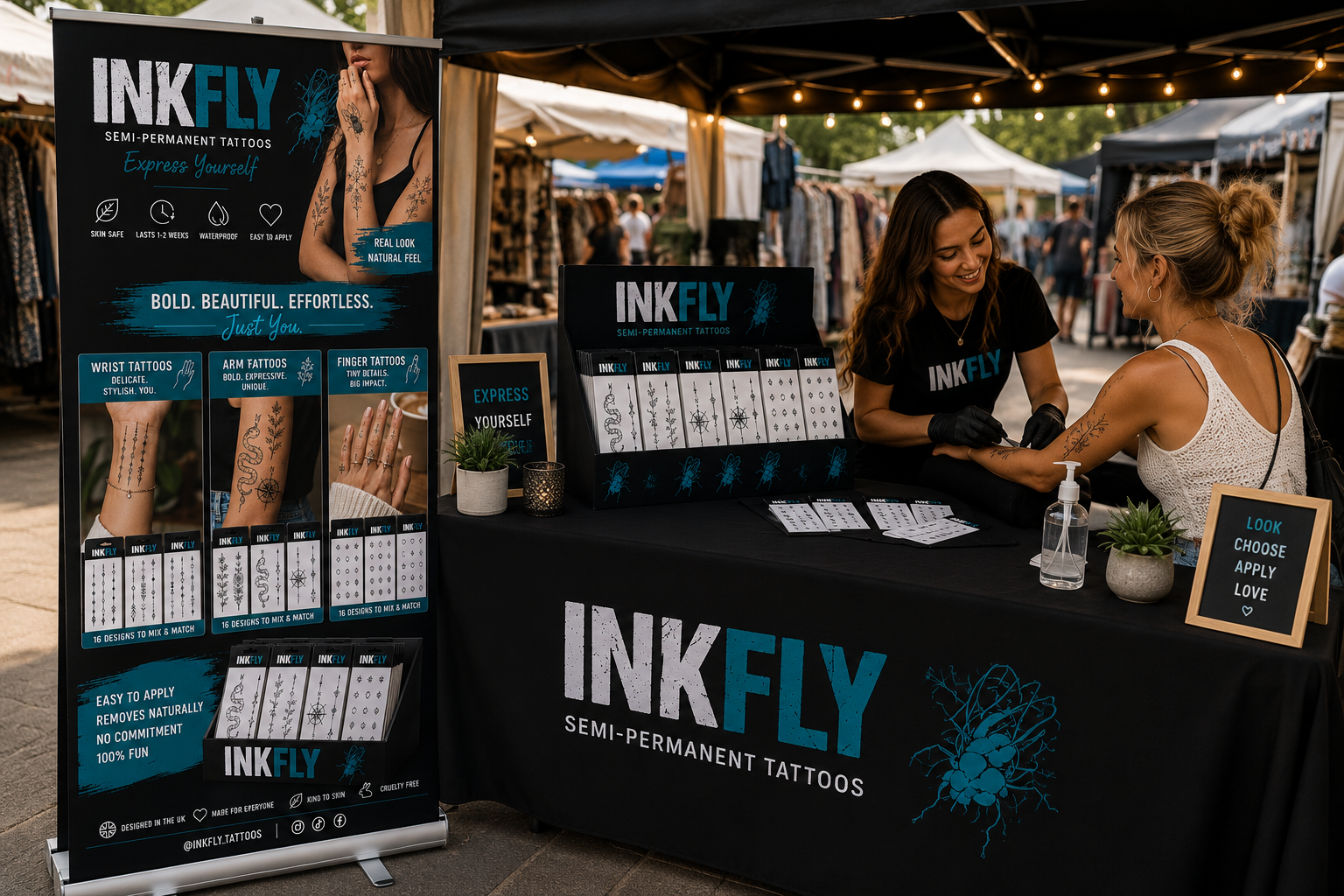 INKFLY booth at an outdoor market, with tattoo products on display and staff assisting a customer