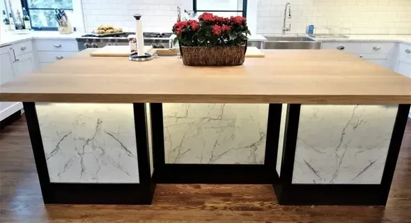 A kitchen island with a basket of flowers on top of it.