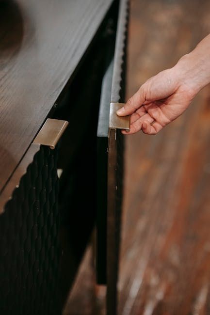 A person is opening a cabinet door with their hand.