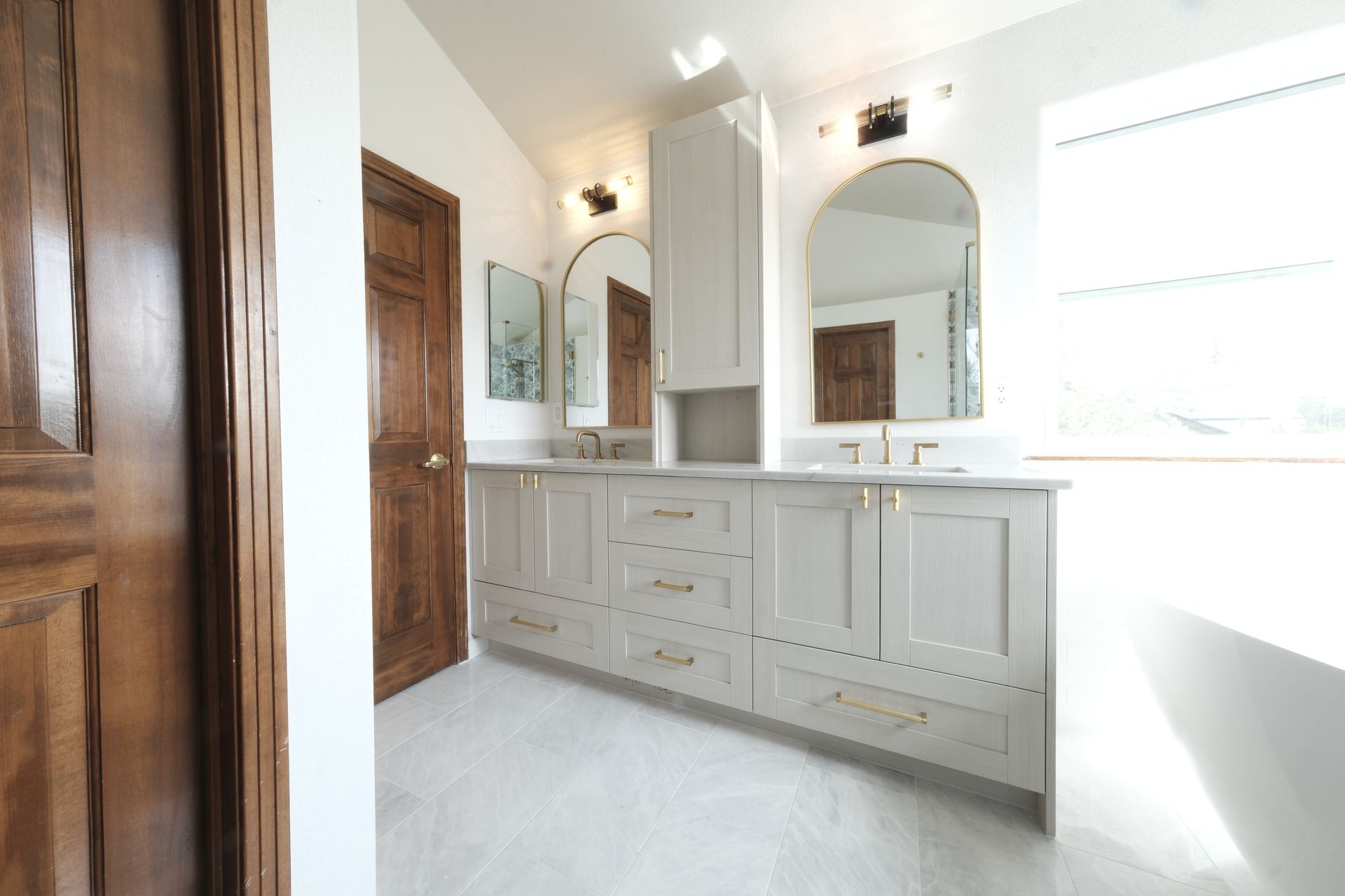 A bathroom with a tub , sink , and window.