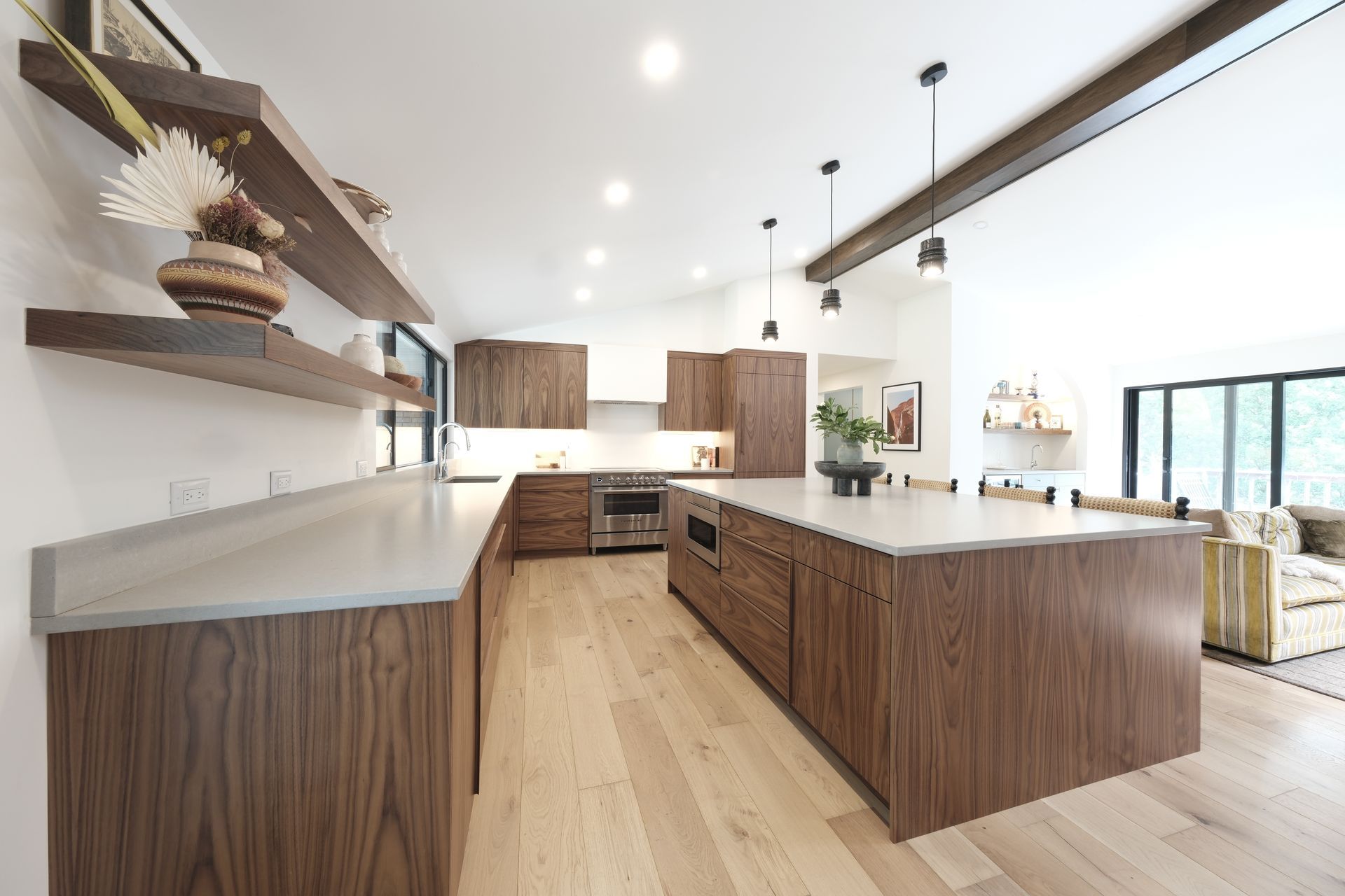 Bright modern kitchen with wood cabinets, white countertops, island, and light hardwood floors