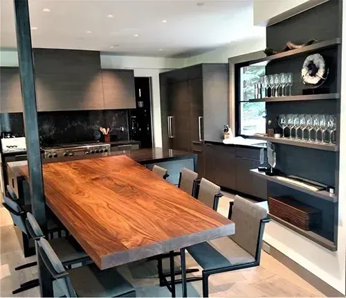 A kitchen with a large wooden table and chairs