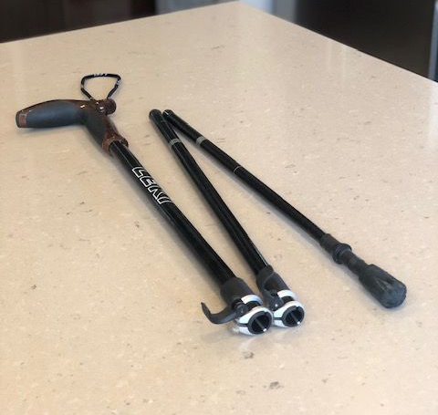 Black and brown Leki folding trekking pole set on a light-colored countertop.