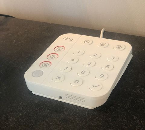 White Ring keypad on a dark surface, with numbered buttons and alarm functions.