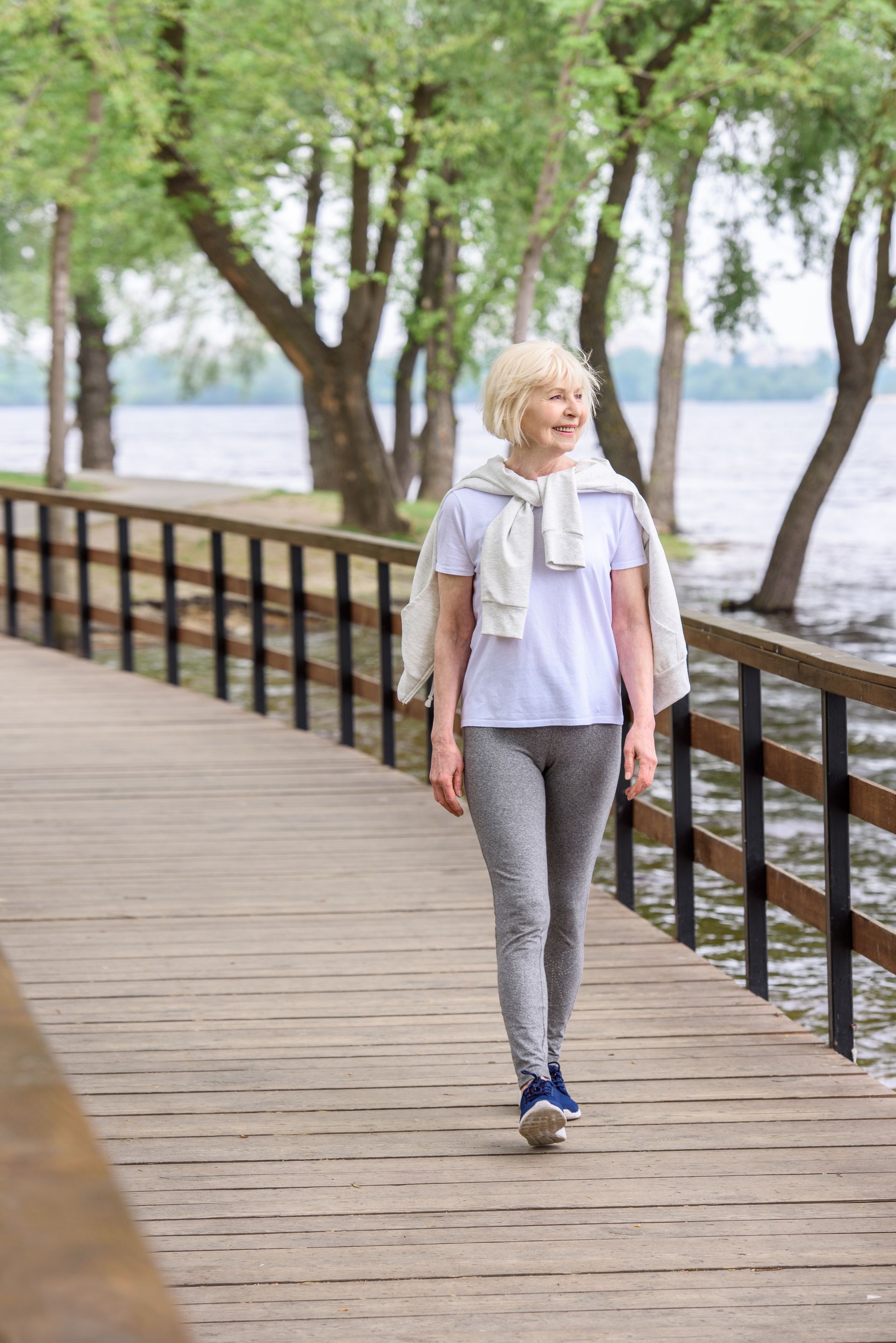 A woman with
smiles as she walks by the water.