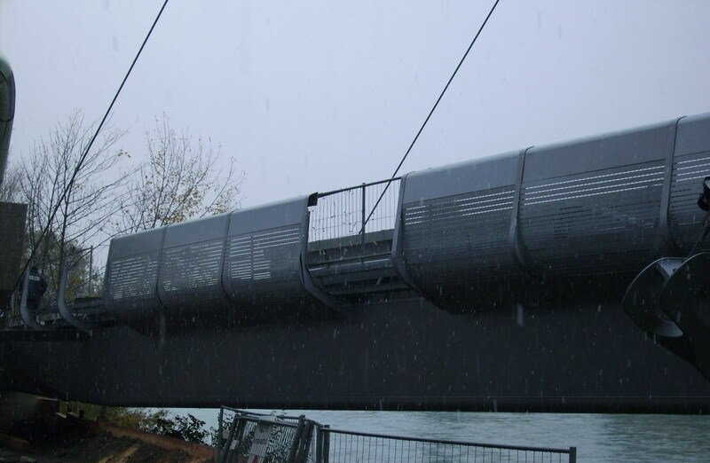 Eine schneebedeckte Fußgängerbrücke über das Wasser an einem grauen Wintertag