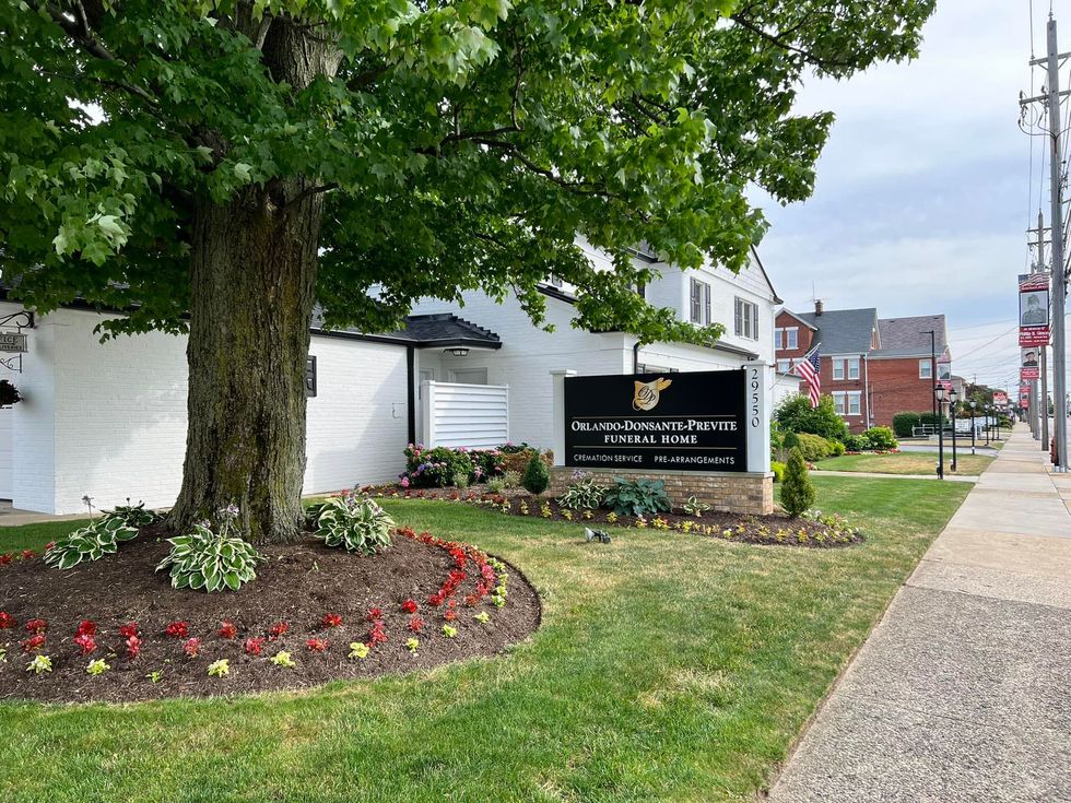 Welcoming funeral home entrance with modern signage guiding families seeking assistance.