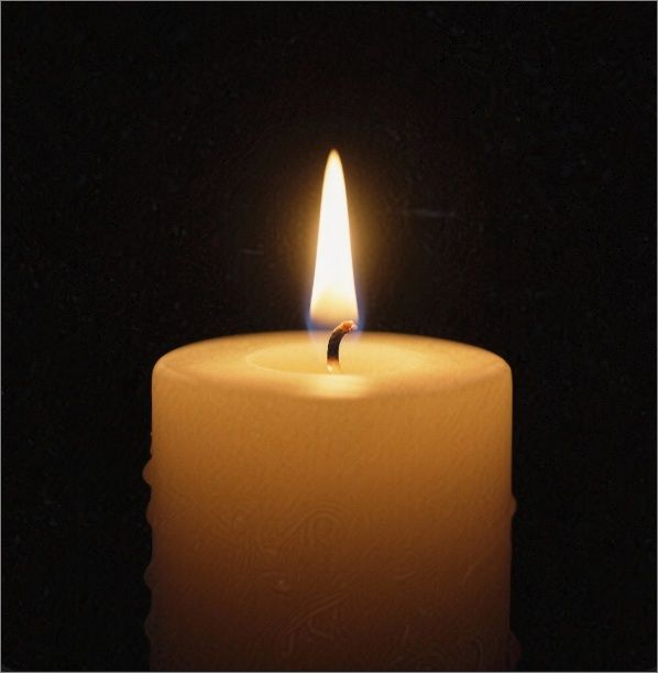 Close-up of lit candle in darkness, cremation services in Wickliffe, OH