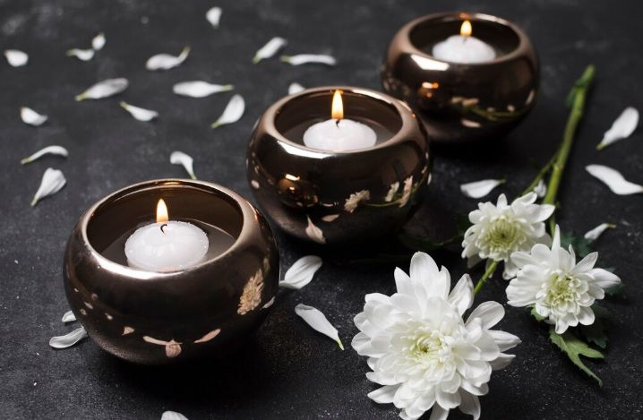Three lit candles with white flowers and petals, funeral homes in Willowick, OH