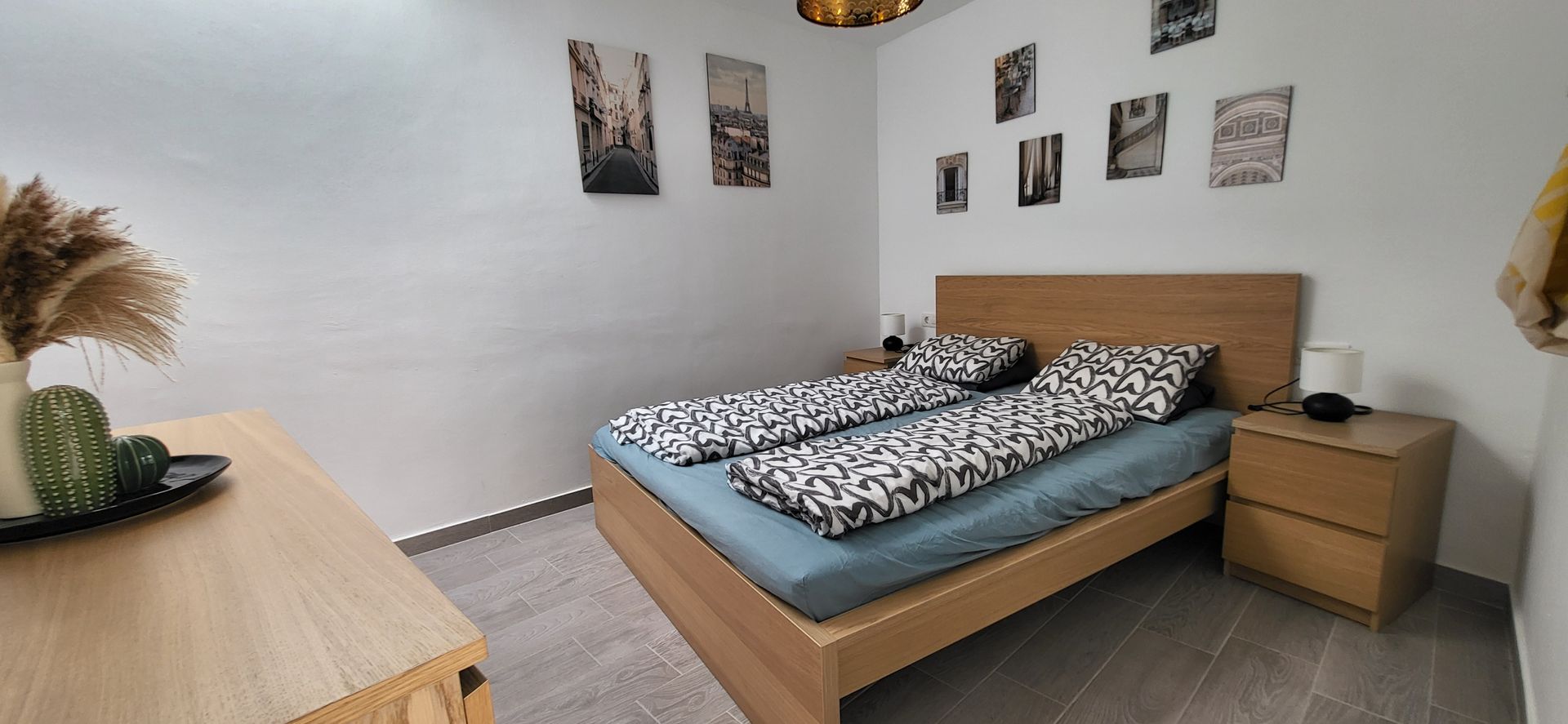 Das erste Schlafzimmer mit Bett, Nachttisch und Kommode.