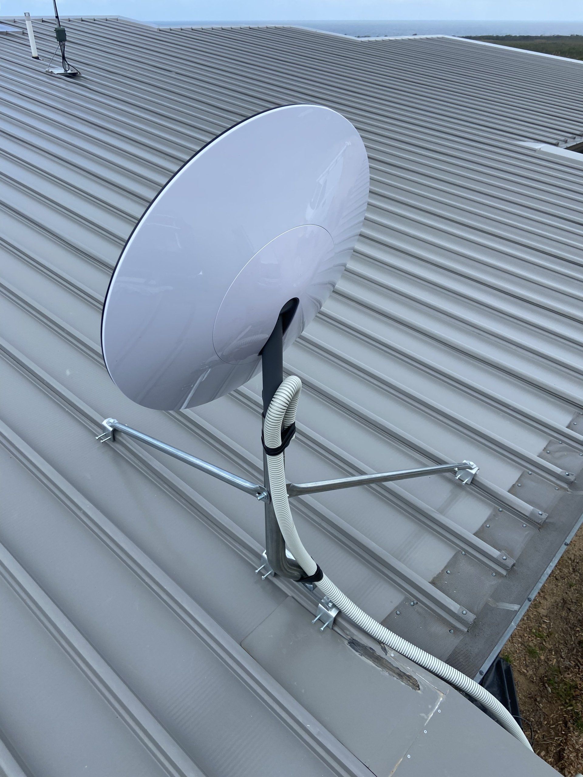 A satellite dish is mounted on the roof of a building.