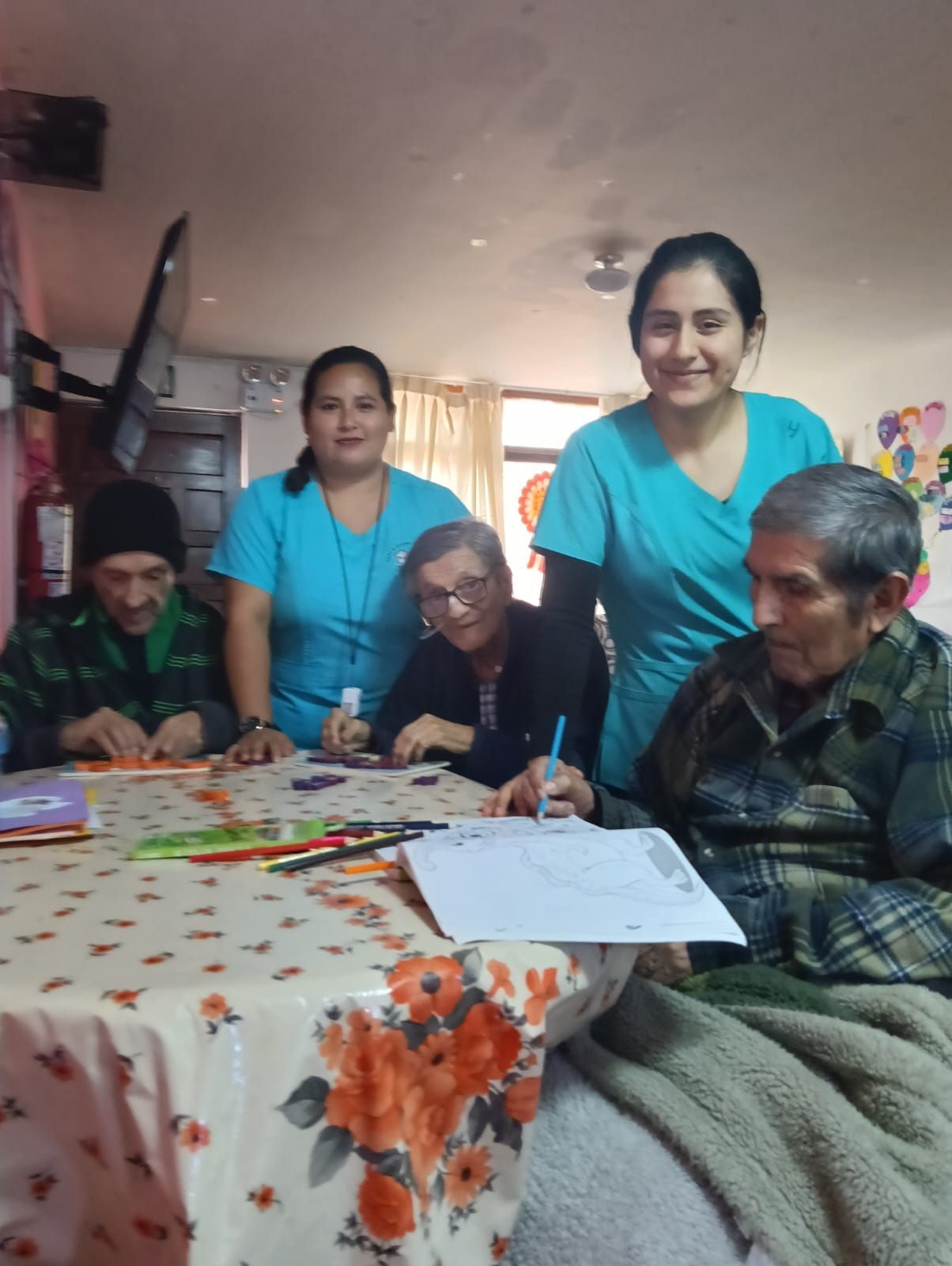 En una acogedora sala interior, varias personas se reunieron alrededor de una mesa para escribir y revisar documentos.