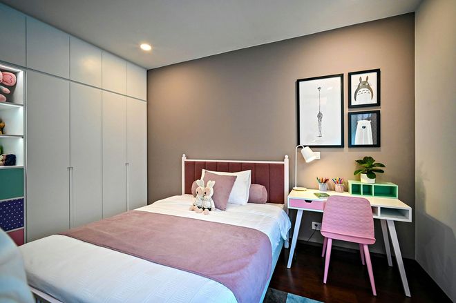 Bedroom with pale blue closet, pink bedspread, desk with pink chair, and art on the wall.